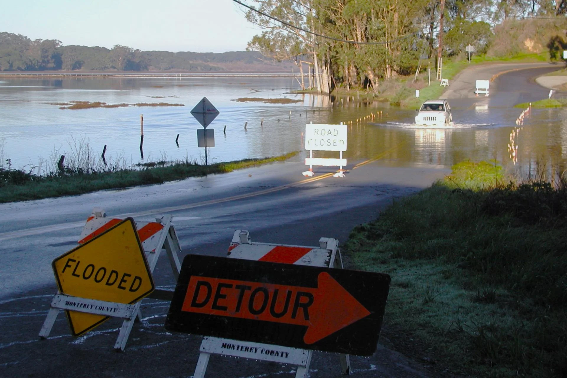 Car driving a through a flooded road.