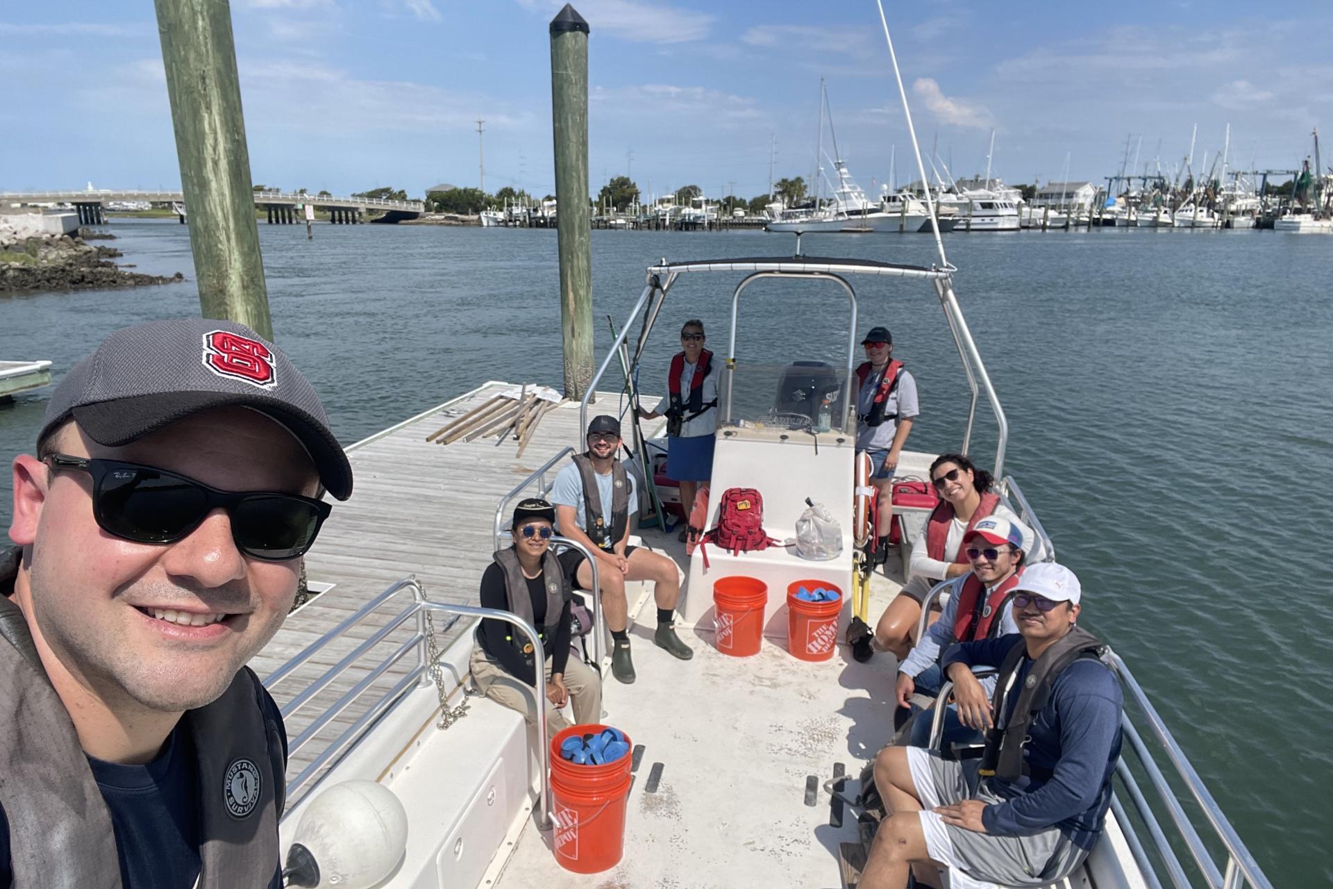 People having a group selfie in a boat.