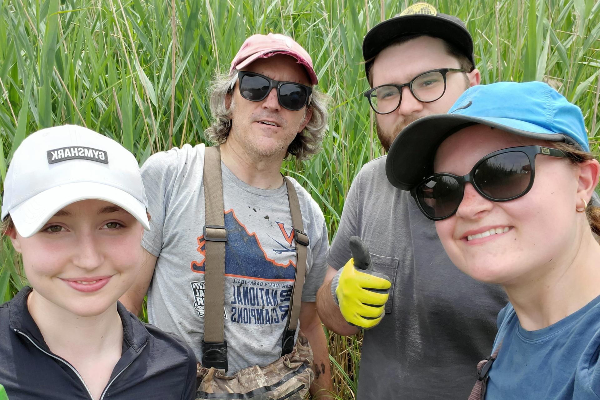 Four people smiling for a group selfie.